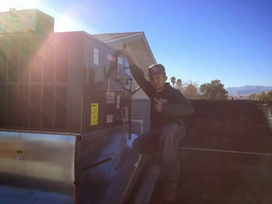 HVAC technician performing HVAC Inspection on a rooftop unit in Garland